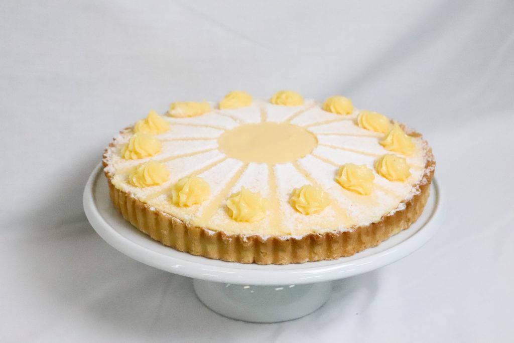 Fresh citrus tart topped with lemon curd and dusted with icing sugar
