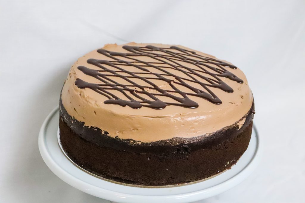 Chocolate cake topped with fresh chocolate icing and chocolate sauce
