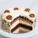 Chocolate and vanilla layered sponge cake topped with whipped icing and grated chocolates on the side