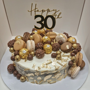 single layer mudcake topped with gold leaf and chocolates