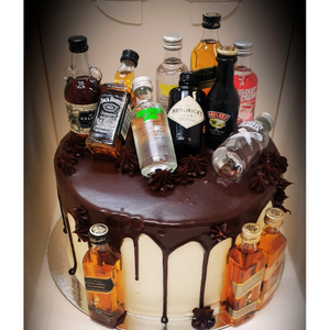 drip cake topped with mini alcohol bottles