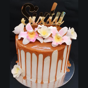 mudcake masked in caramel cream and caramel drip topped with edible flowers