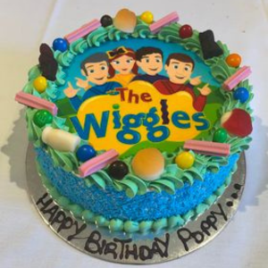 sponge cake with blue icing and wiggles edible image and decorated with lollies