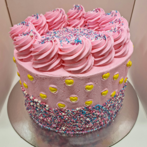sponge cake masked with pink icing and topped with sprinkles