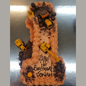 1 year old birthday cake with trucks diggers and chocolate boulders