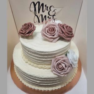 tiered wedding mudcake topped with edible roses and a Mr and Mrs topper on a rose gold cake board